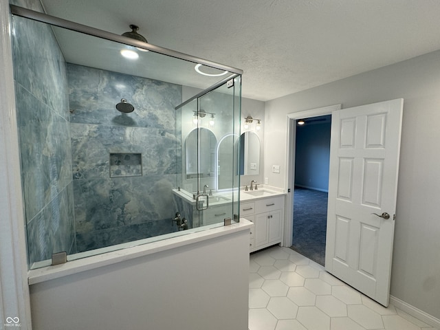 bathroom with vanity, tile patterned floors, a textured ceiling, and tiled shower