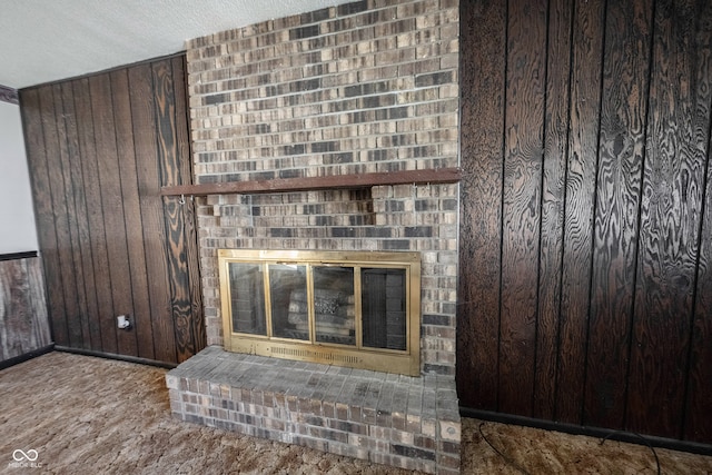 details featuring wooden walls, a textured ceiling, and a brick fireplace