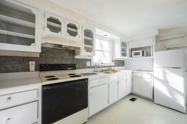 kitchen featuring white appliances, white cabinetry, sink, and backsplash