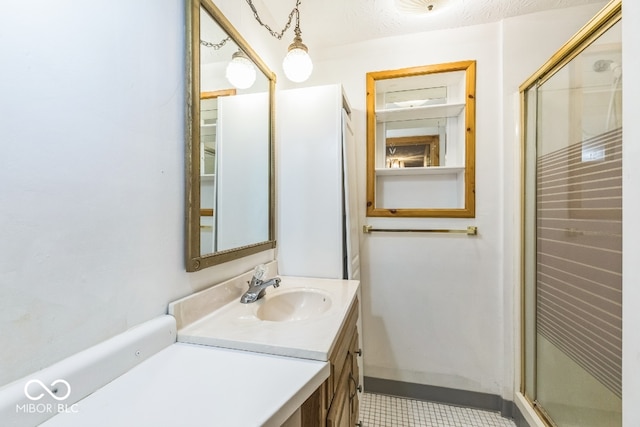 bathroom featuring an enclosed shower, vanity, a textured ceiling, and tile patterned flooring