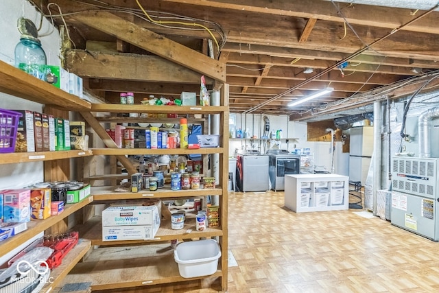 storage area featuring washer and clothes dryer and heating unit