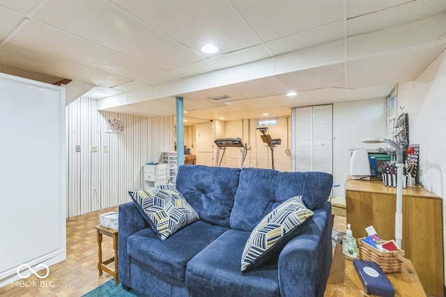 living room with a drop ceiling and parquet floors