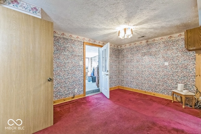 empty room with a textured ceiling and carpet floors