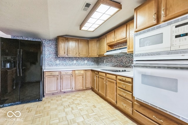 kitchen featuring a textured ceiling, tasteful backsplash, white appliances, and light parquet floors