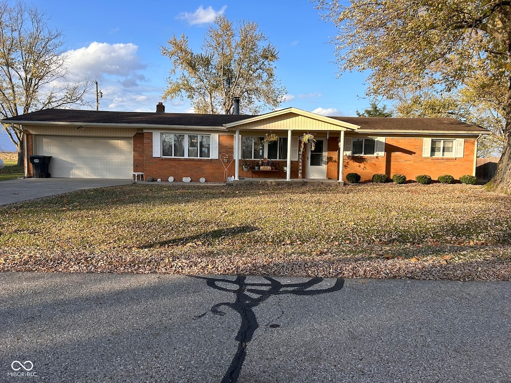 ranch-style house featuring a garage, a porch, and a front lawn