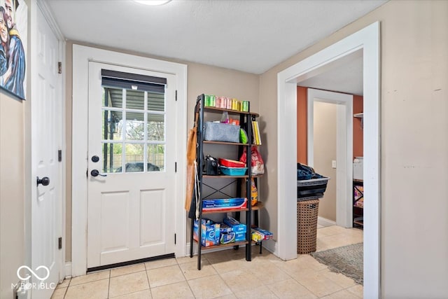 doorway to outside featuring light tile patterned floors and a textured ceiling