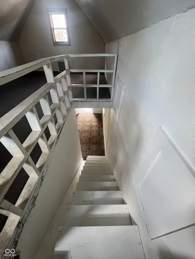 stairs featuring vaulted ceiling