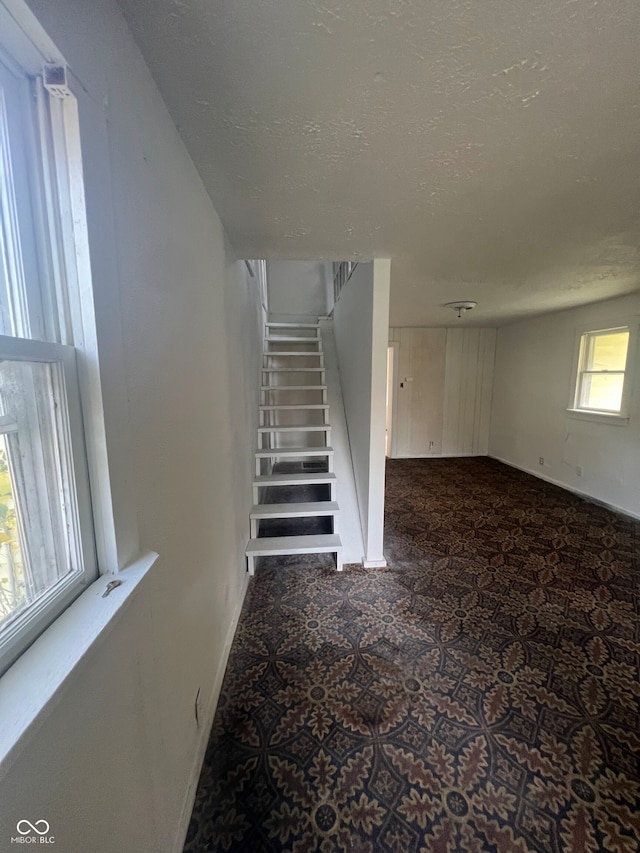 staircase featuring a wealth of natural light and a textured ceiling