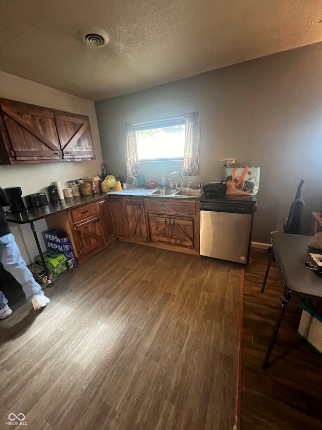 kitchen with dishwasher, a textured ceiling, dark wood-type flooring, and sink