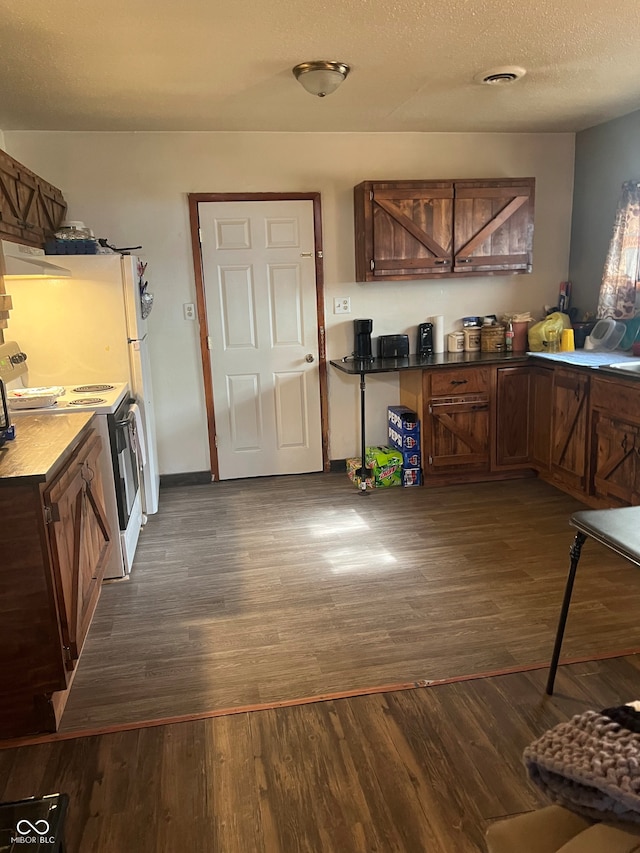 kitchen featuring dark hardwood / wood-style flooring, a textured ceiling, extractor fan, and white range