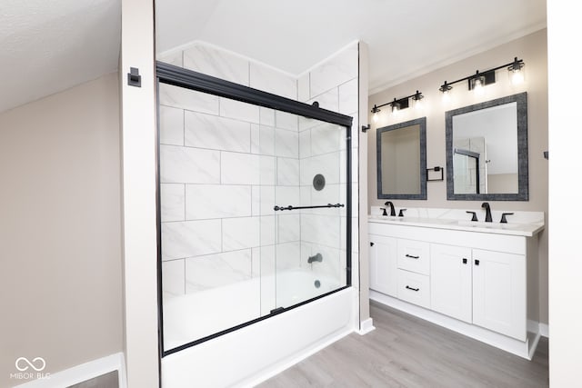 bathroom with vaulted ceiling, hardwood / wood-style floors, a textured ceiling, combined bath / shower with glass door, and vanity