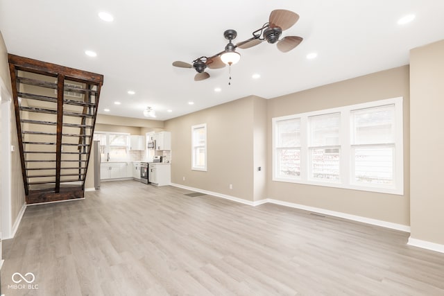 unfurnished living room featuring light hardwood / wood-style floors and ceiling fan