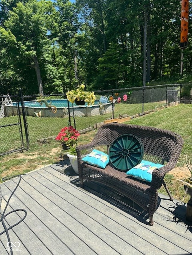 wooden deck with a lawn and a swimming pool