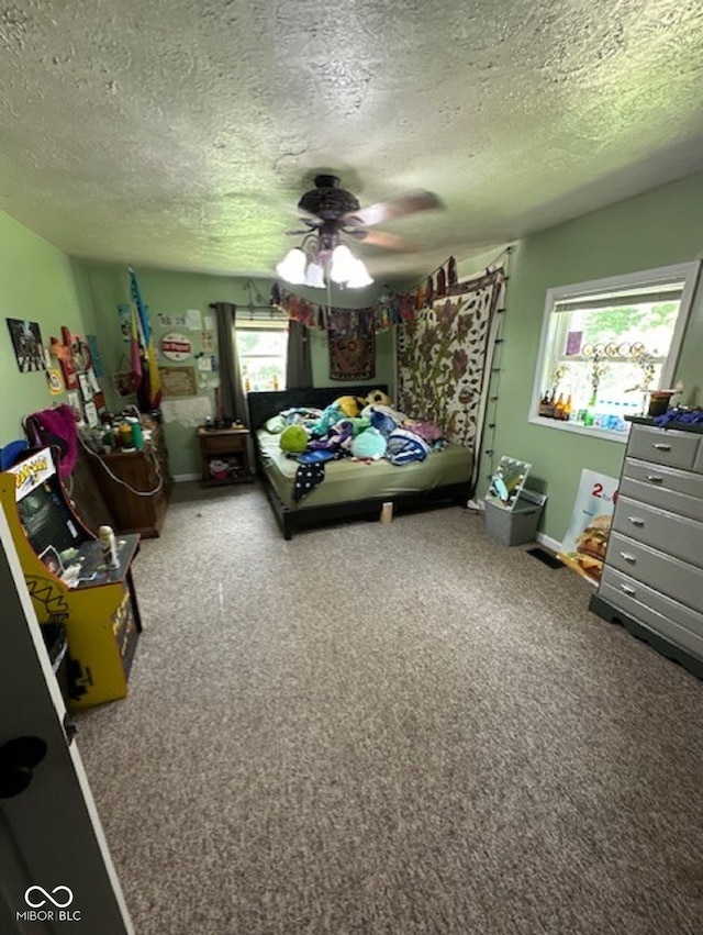 bedroom with carpet, a textured ceiling, and ceiling fan