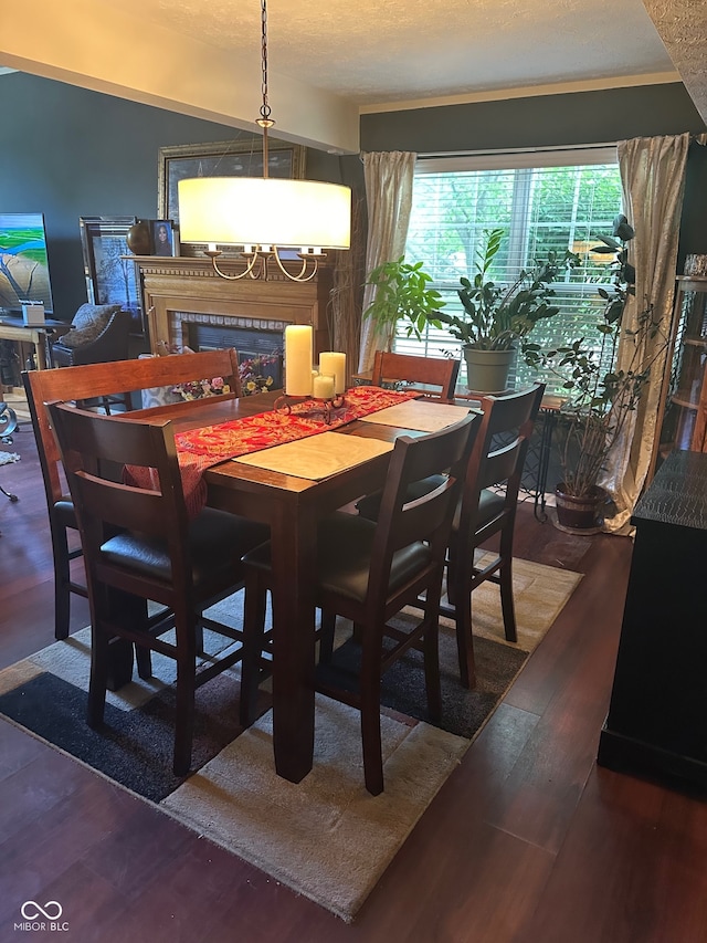 dining area featuring wood-type flooring and a textured ceiling