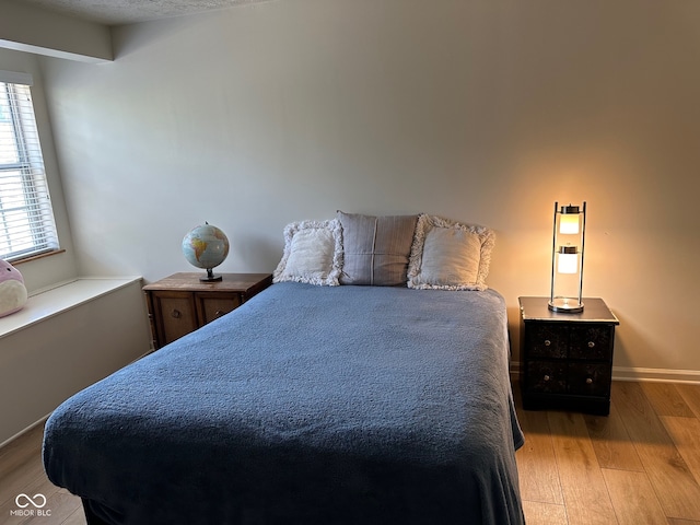 bedroom featuring light hardwood / wood-style floors and a textured ceiling