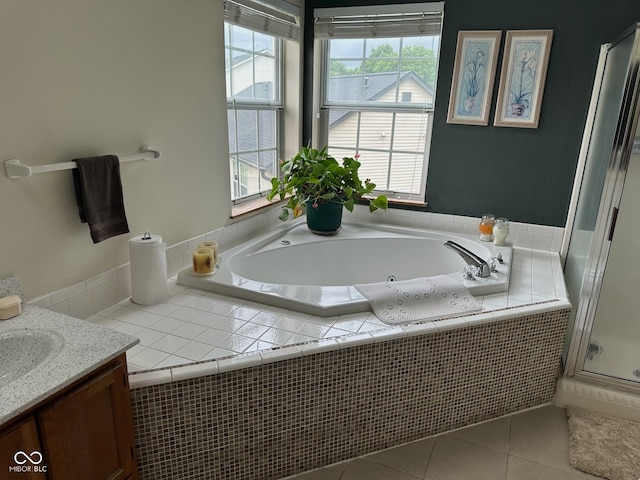 bathroom with plus walk in shower, vanity, and tile patterned flooring