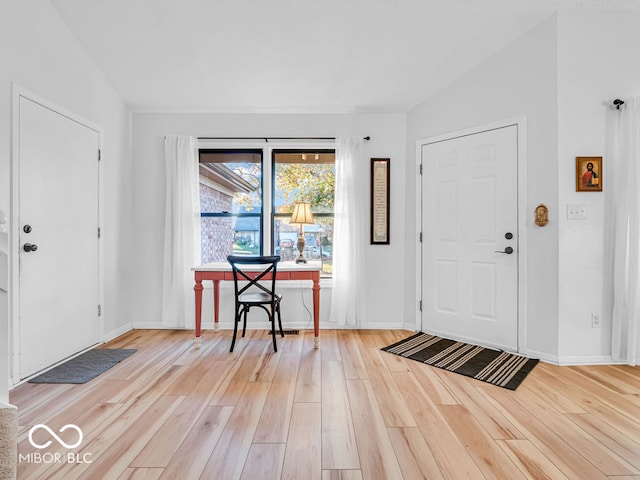 foyer entrance with lofted ceiling and light hardwood / wood-style flooring