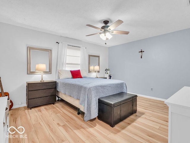 bedroom featuring a textured ceiling, light hardwood / wood-style flooring, and ceiling fan