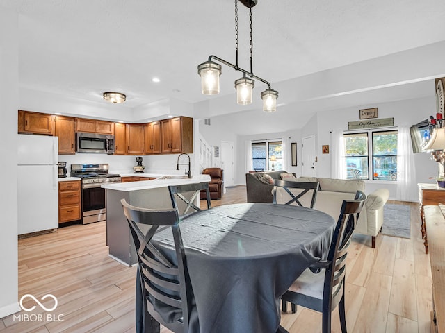 dining area featuring sink and light hardwood / wood-style flooring