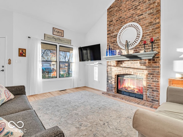 living room featuring a fireplace, light hardwood / wood-style flooring, and lofted ceiling