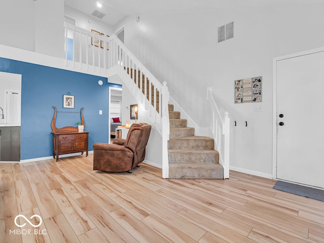 foyer featuring high vaulted ceiling and light hardwood / wood-style floors