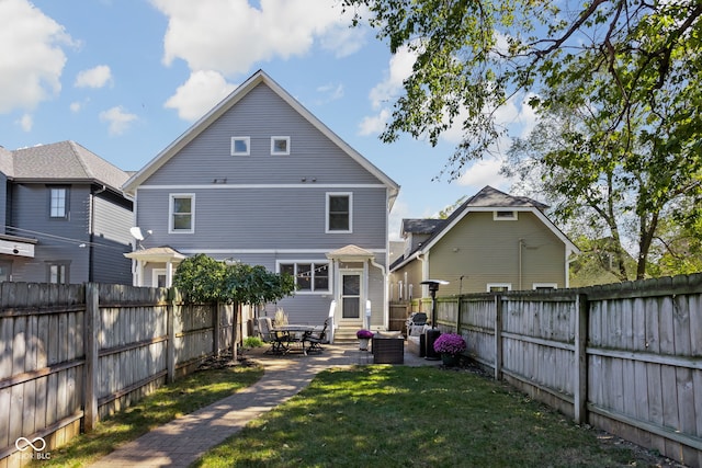 back of property featuring a lawn and a patio area