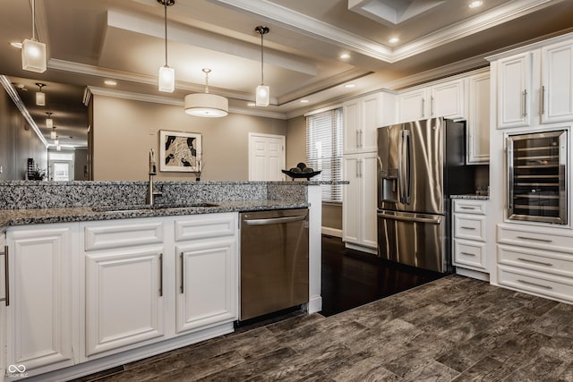 kitchen featuring appliances with stainless steel finishes, wine cooler, a raised ceiling, decorative light fixtures, and white cabinetry