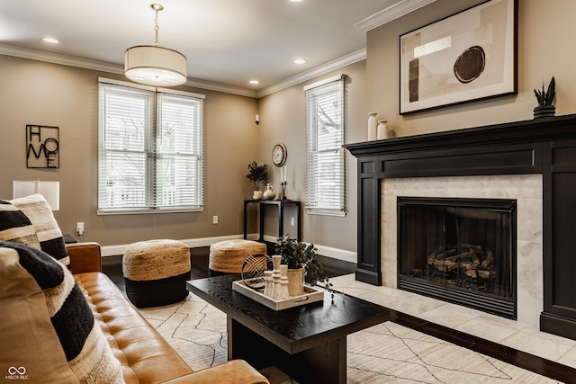 living room featuring a tiled fireplace, light hardwood / wood-style floors, and ornamental molding