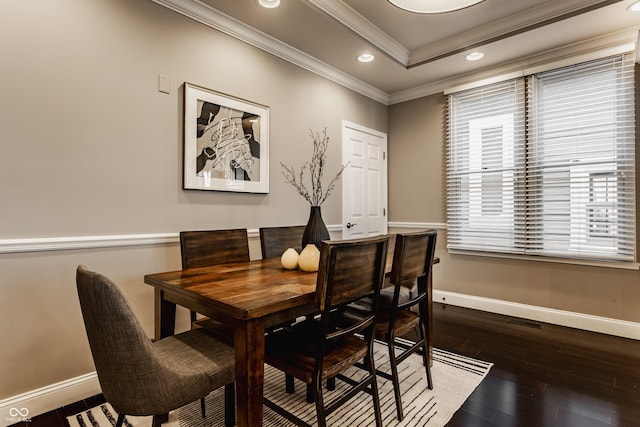 dining room featuring hardwood / wood-style flooring, a raised ceiling, and ornamental molding