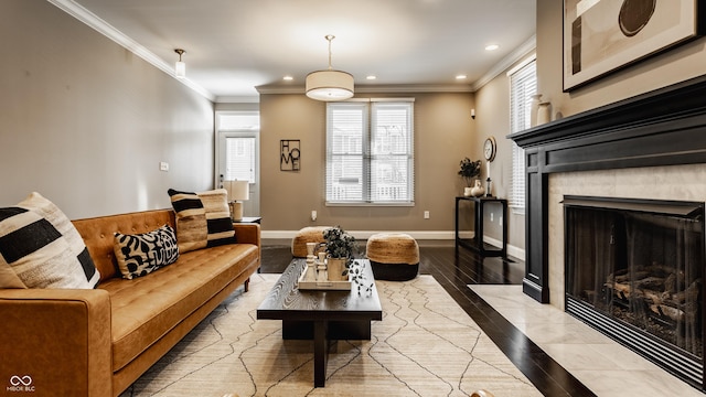 living room featuring a tile fireplace, light hardwood / wood-style flooring, and ornamental molding