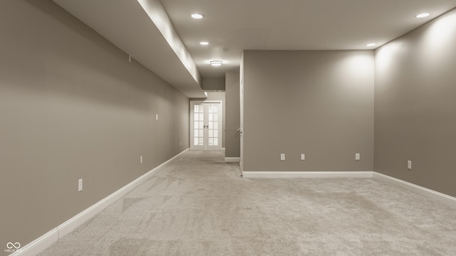 carpeted spare room featuring french doors