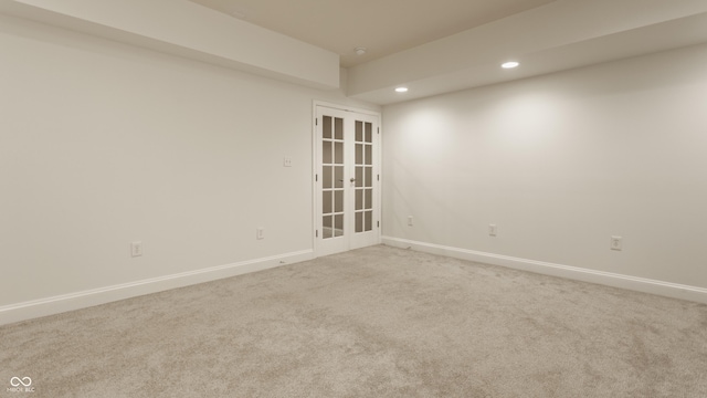 unfurnished room featuring french doors and light colored carpet