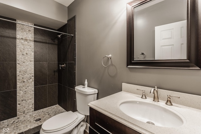 bathroom featuring vanity, toilet, and tiled shower