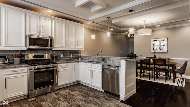 kitchen with sink, hanging light fixtures, stainless steel appliances, kitchen peninsula, and white cabinets