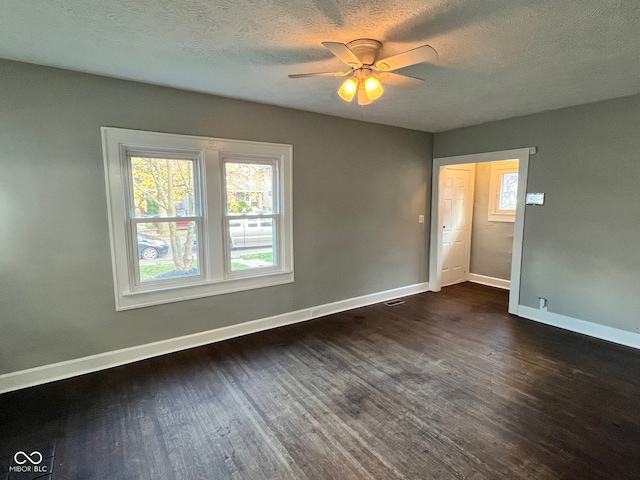 unfurnished room with a textured ceiling, dark hardwood / wood-style floors, and ceiling fan