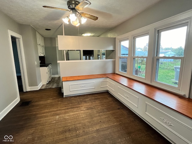 kitchen featuring dark wood-type flooring, white electric range oven, a textured ceiling, white cabinetry, and stainless steel fridge