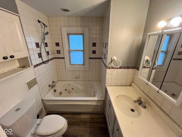 full bathroom featuring toilet, vanity, tiled shower / bath, and wood-type flooring