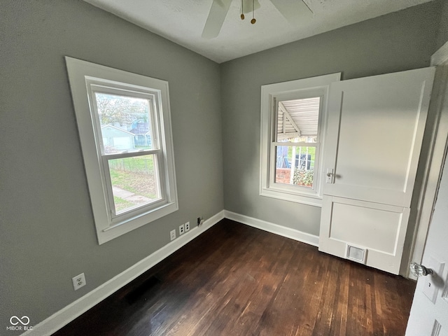 empty room with dark hardwood / wood-style flooring and ceiling fan