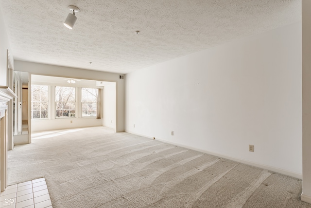 empty room featuring light colored carpet and a textured ceiling