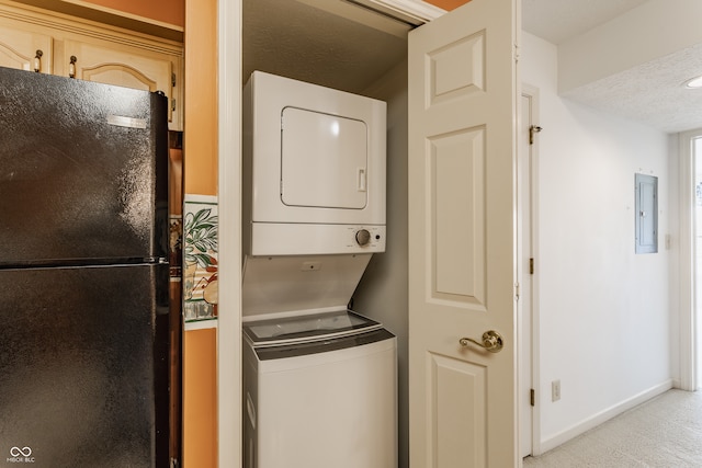 washroom featuring electric panel, a textured ceiling, and stacked washer and dryer