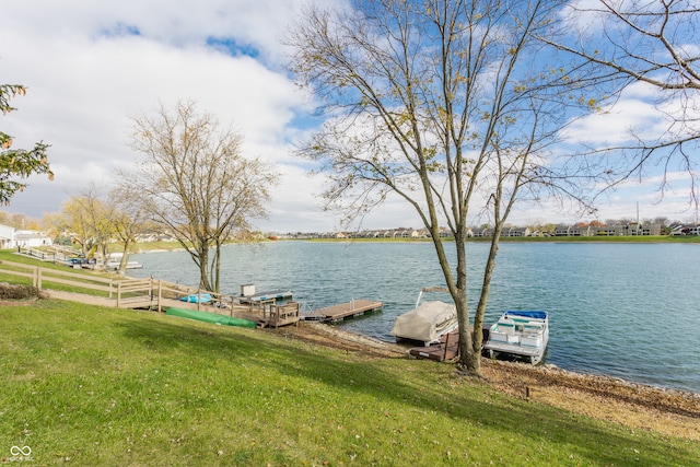 view of dock with a water view and a lawn