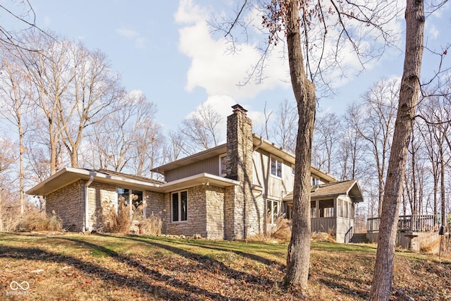 view of side of home with a lawn and a sunroom