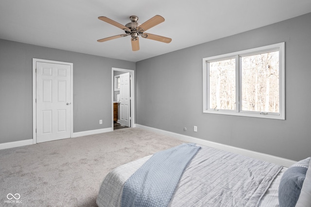 carpeted bedroom featuring ensuite bath and ceiling fan