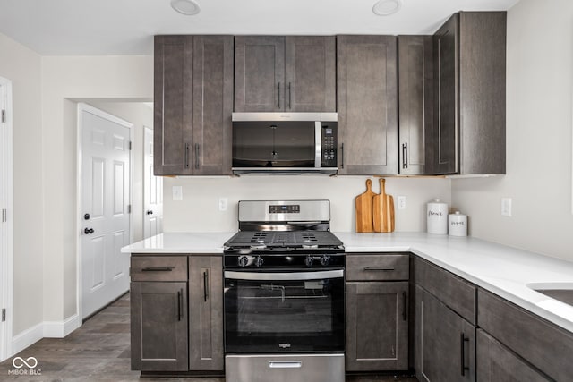 kitchen with dark hardwood / wood-style floors, dark brown cabinets, and appliances with stainless steel finishes