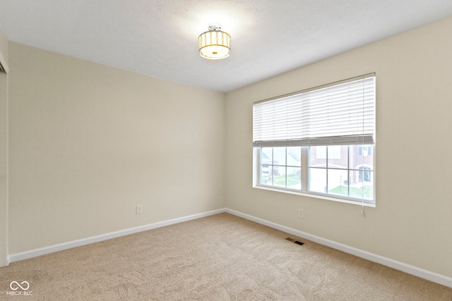 carpeted spare room featuring a textured ceiling