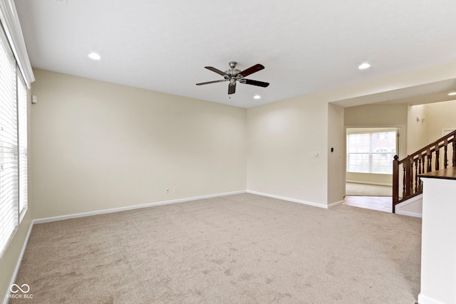 unfurnished room featuring light colored carpet and ceiling fan