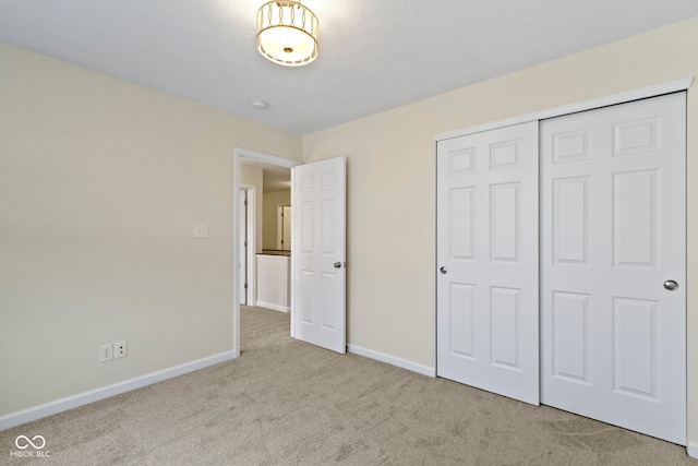 unfurnished bedroom with light carpet and a closet