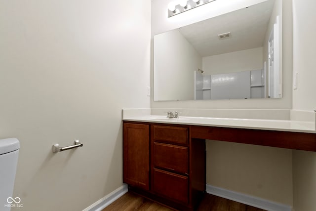 bathroom with vanity, wood-type flooring, and toilet