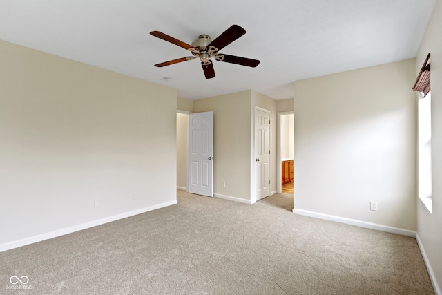 unfurnished room featuring a healthy amount of sunlight, ceiling fan, and light colored carpet